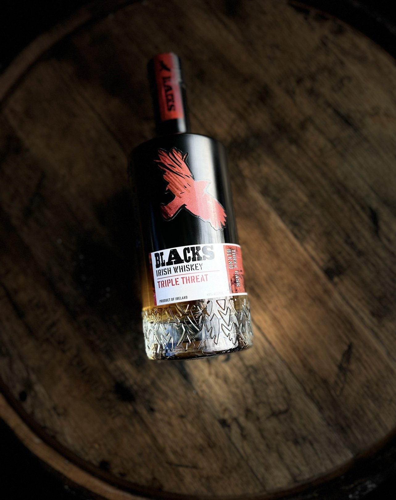 IMG_5817 Bottle of Blacks Irish Whiskey Triple Threat on rustic wooden barrel background.